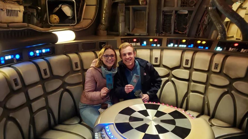 A man and woman sat at a round table designed to look like it is on a spaceship