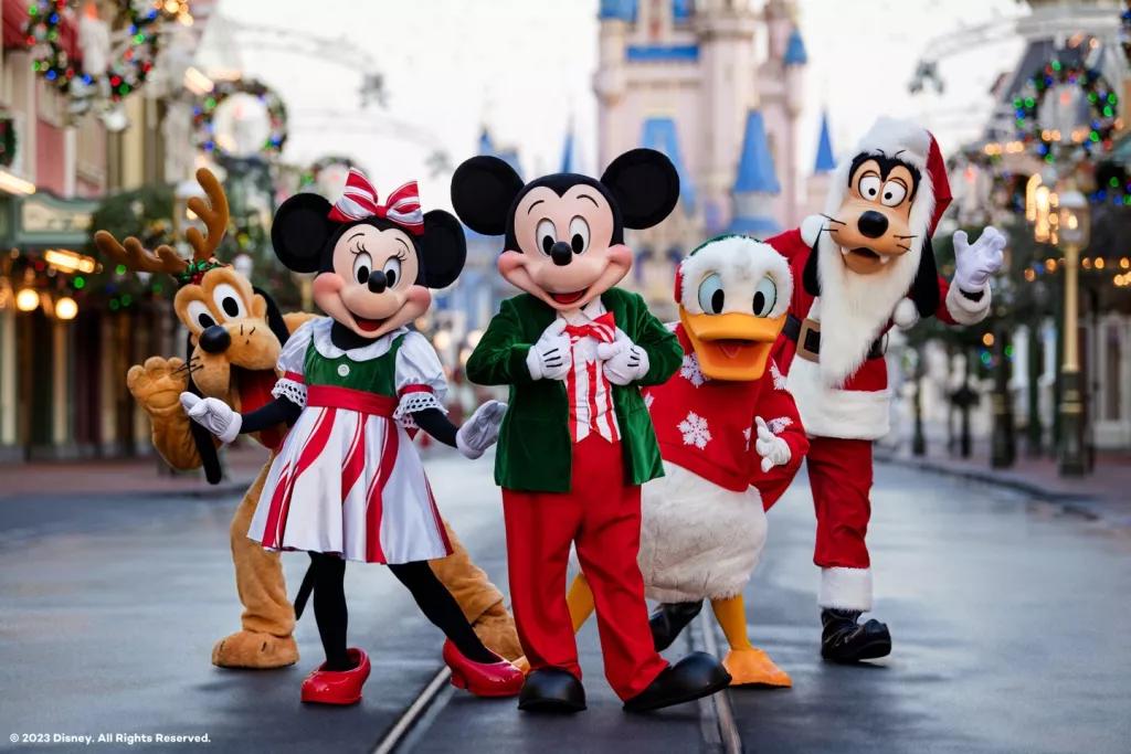 Mickey Mouse, Minnie Mouse and their friends standing on Main Street USA in their Christmas outfits