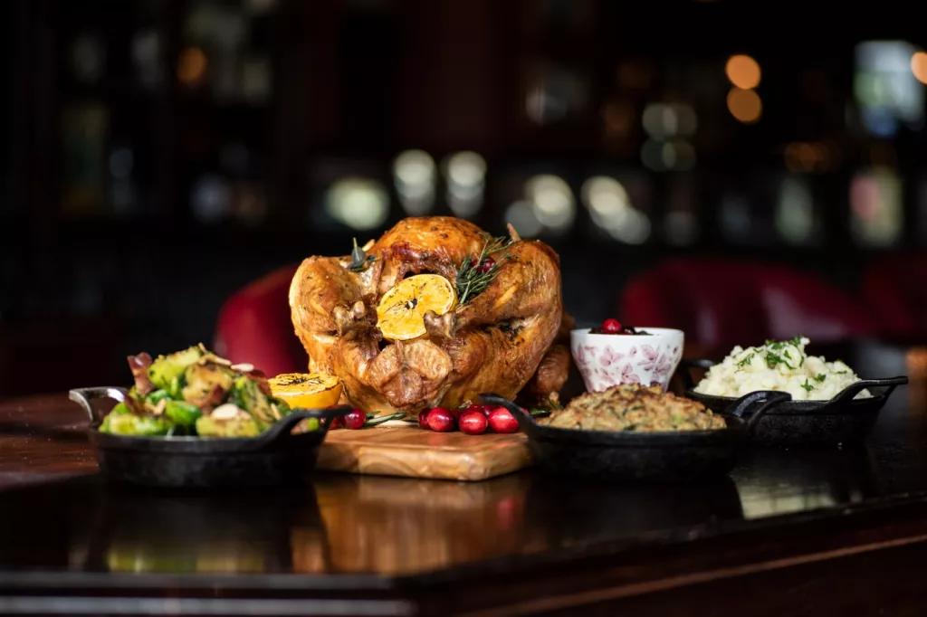 A roast turkey, brussel sprouts, mashed potato and stuffing on a table