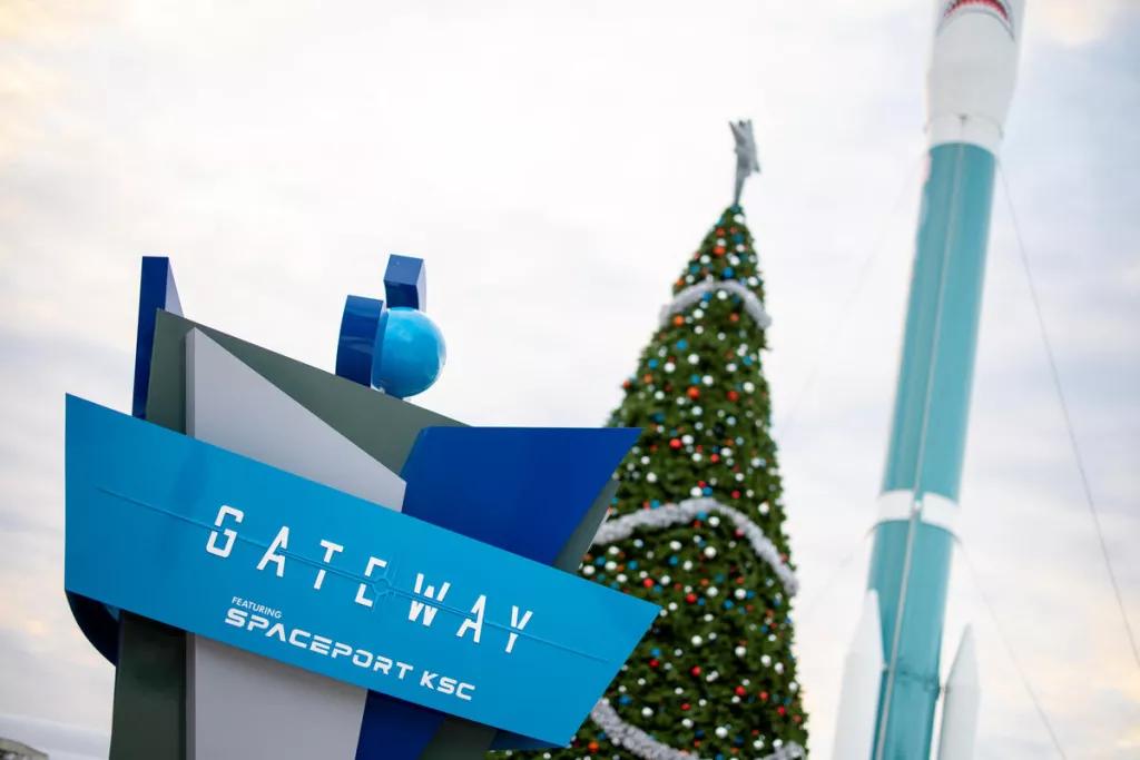 The Gateway Deep Space Launch Complex sign in front of a large Christmas tree 