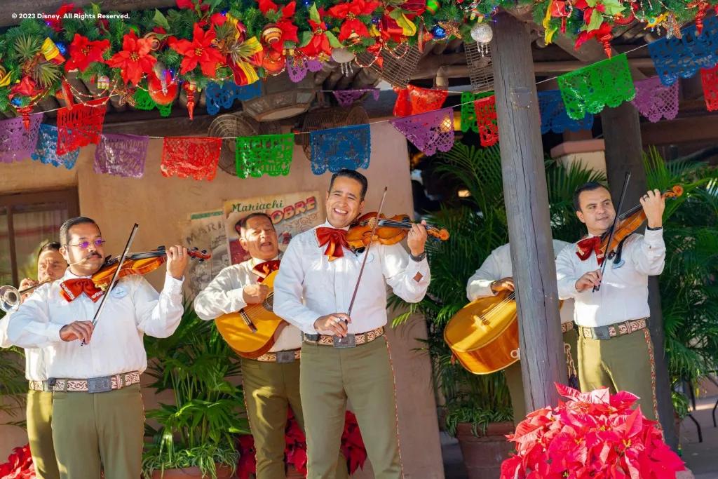 A band playing string instruments and wearing traditional Mexican outfits