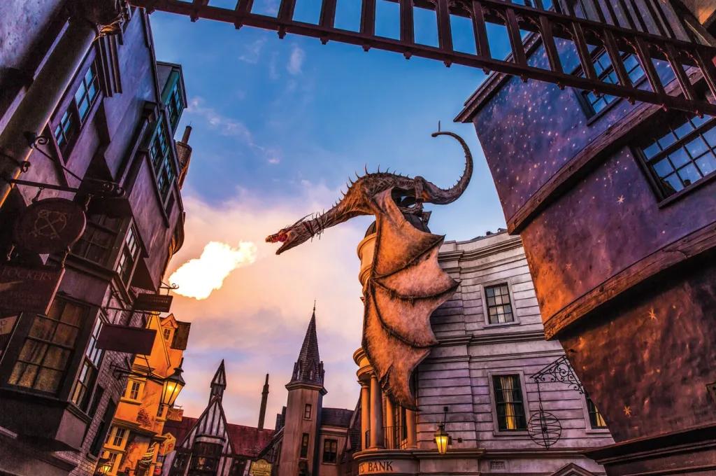 A dragon on top of a building breathing fire into the sky at sunrise