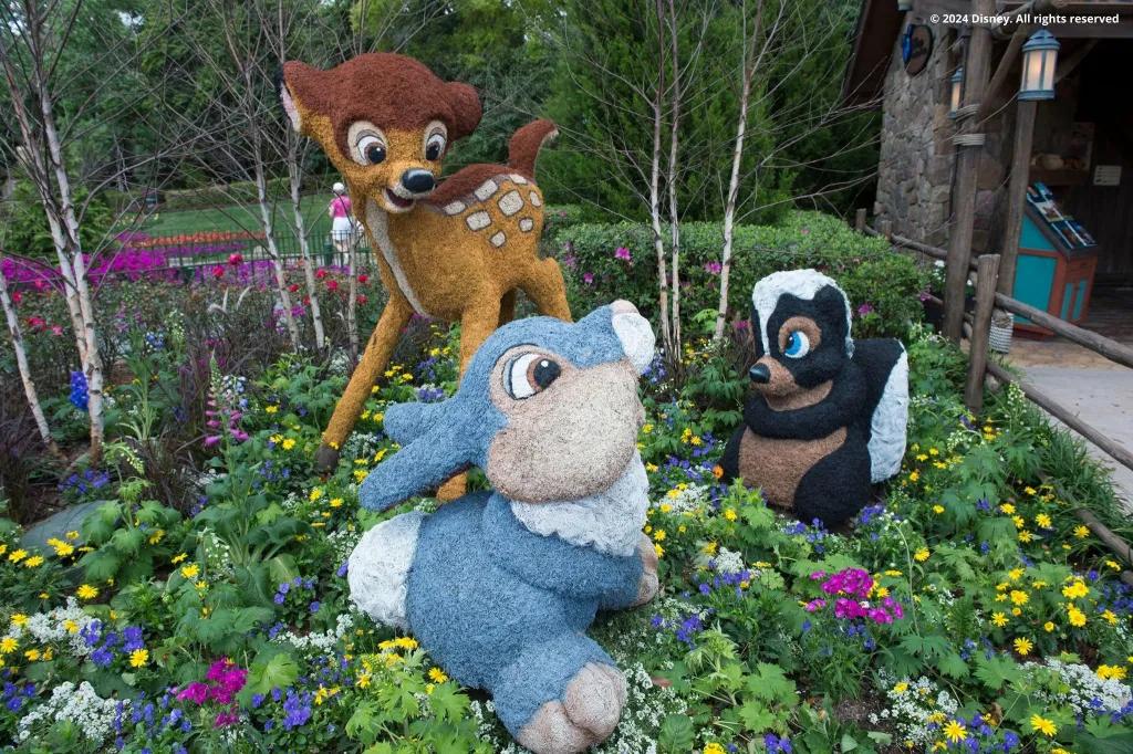 Topiaries shaped like Bambi, Thumper and Flower from Bambi in a flower bed