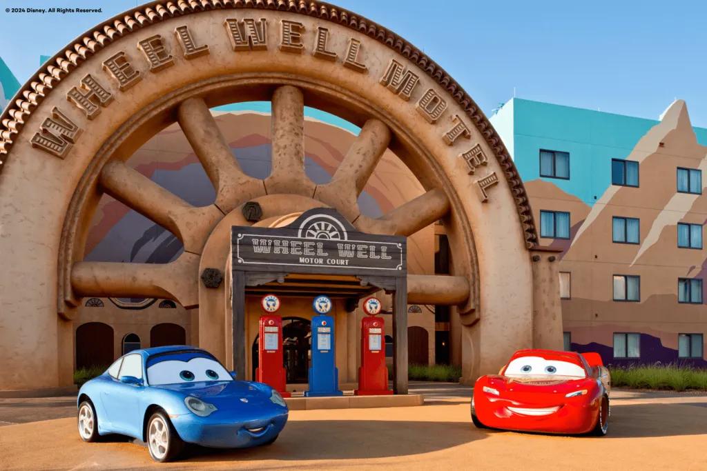Models of Lightning McQueen and Sally from Pixar's Cars in front of a hotel building