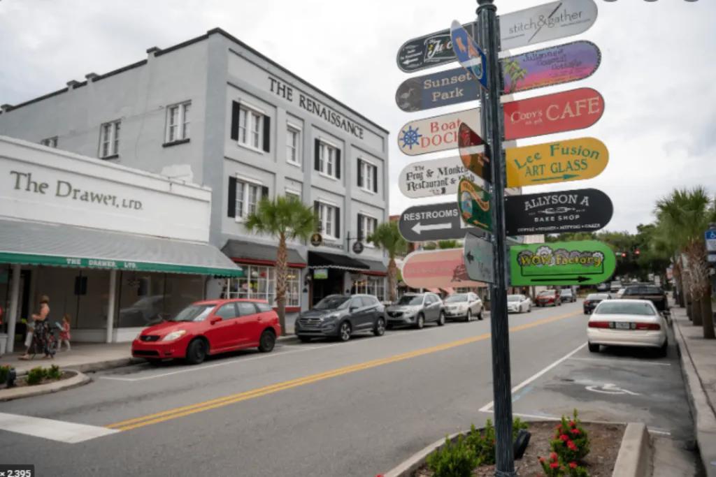 A street with a sign pointing to multiple dining and shopping locations 