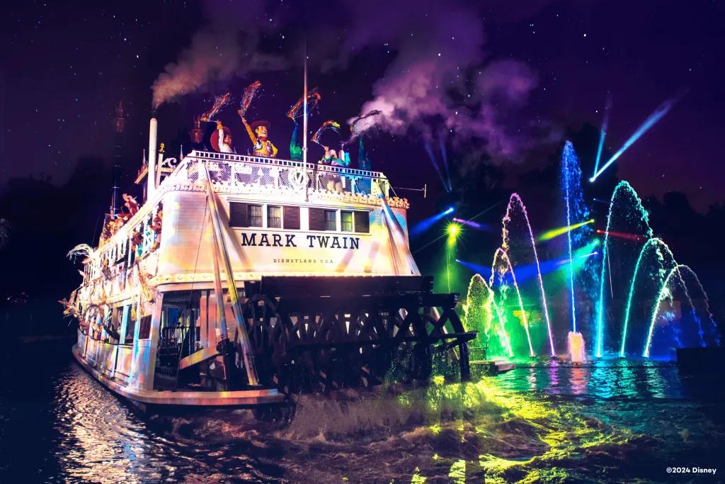 Disney Characters riding on an old fashioned riverboat with brightly lit up fountains in the background