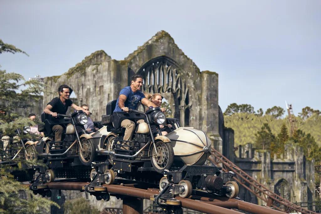 People riding a rollercoaster designed to look like a motorbike and side car