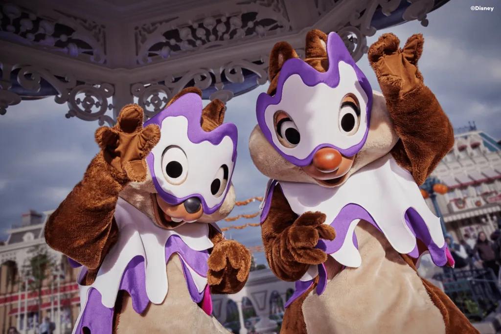Chip and Dale posing for the camera wearing white and purple Halloween masks