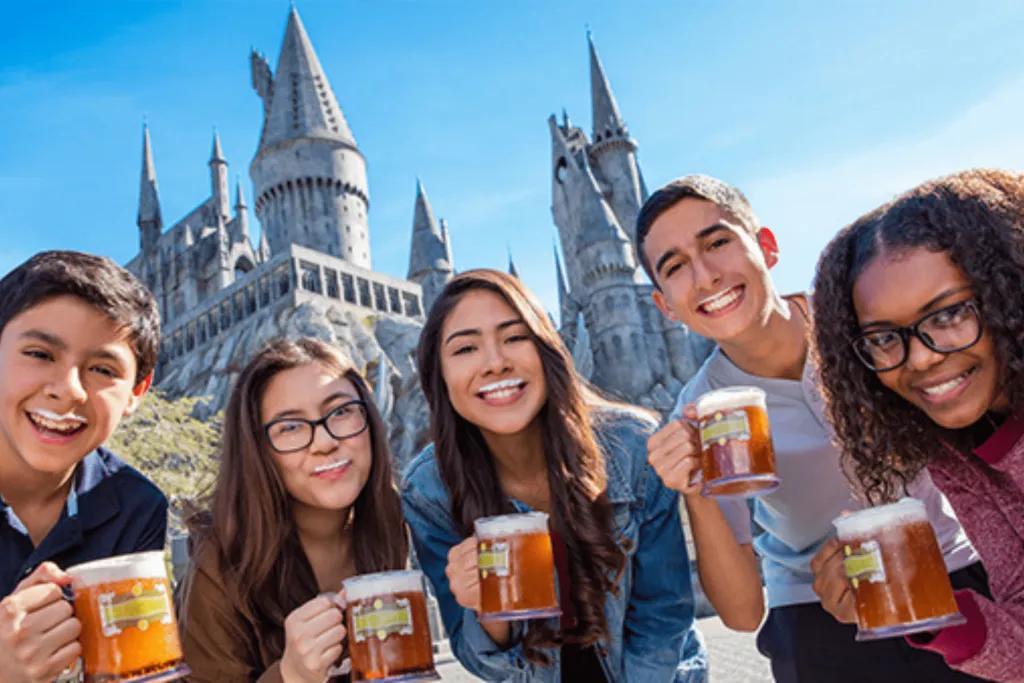 A group of friends drinking Butterbeer in front of Hogwarts Castle