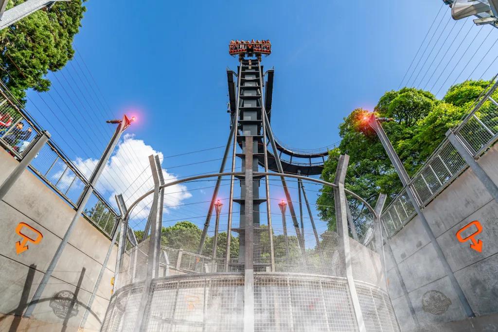 Looking up at a ride car at the top of a vertical drop