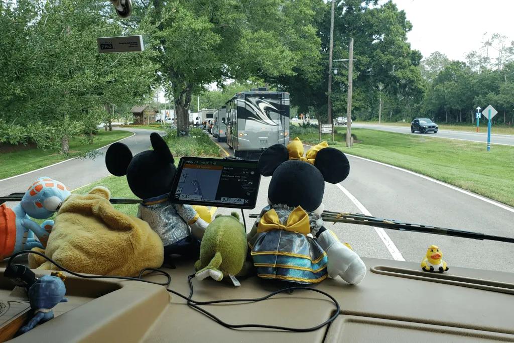 Plush toys lined up on the dashboard, including Mickey, Minnie and the gator from the Princess and the frog.