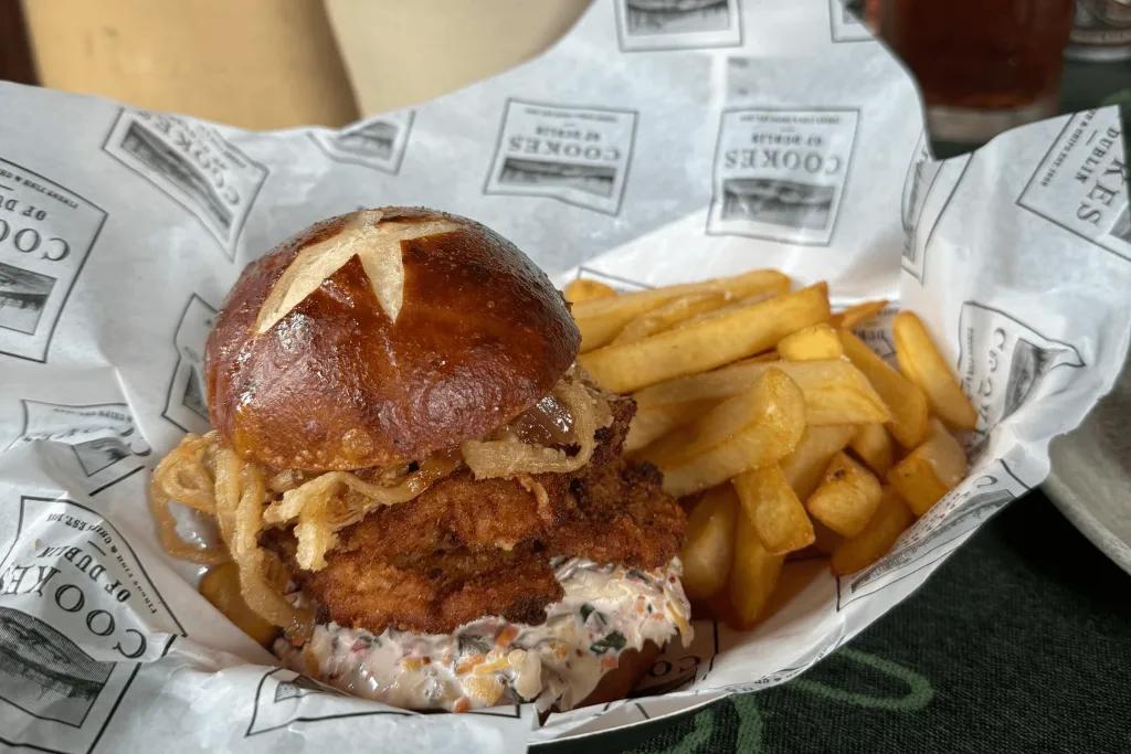 Crispy chicken burger with a sauce and crispy onions in with a side of delicious fries. 