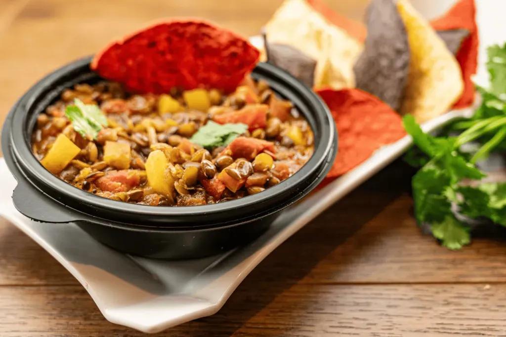  Eine Schüssel Linsen-Chili mit Tortilla-Chips als Beilage