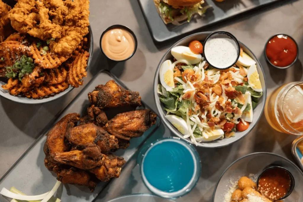 Many dishes available with chicken wings, fries and an egg salad with different sauces including ketchup, pink sauce and more.