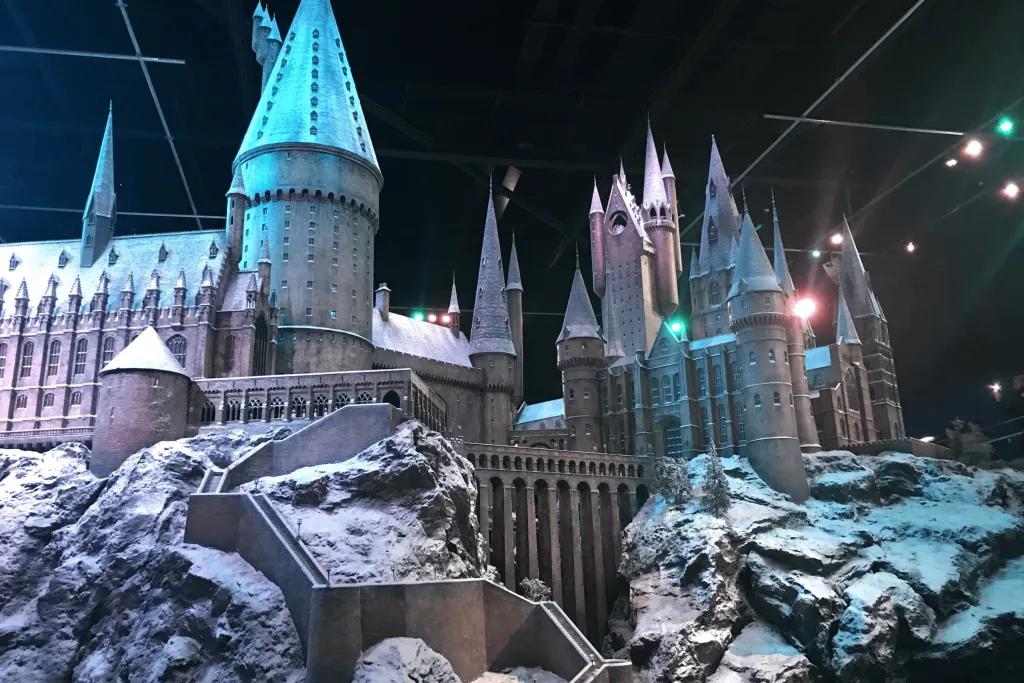 Huge model of Hogwarts Castle, a giant grey castle with pointy roofs and large bridges on top of rocks.
