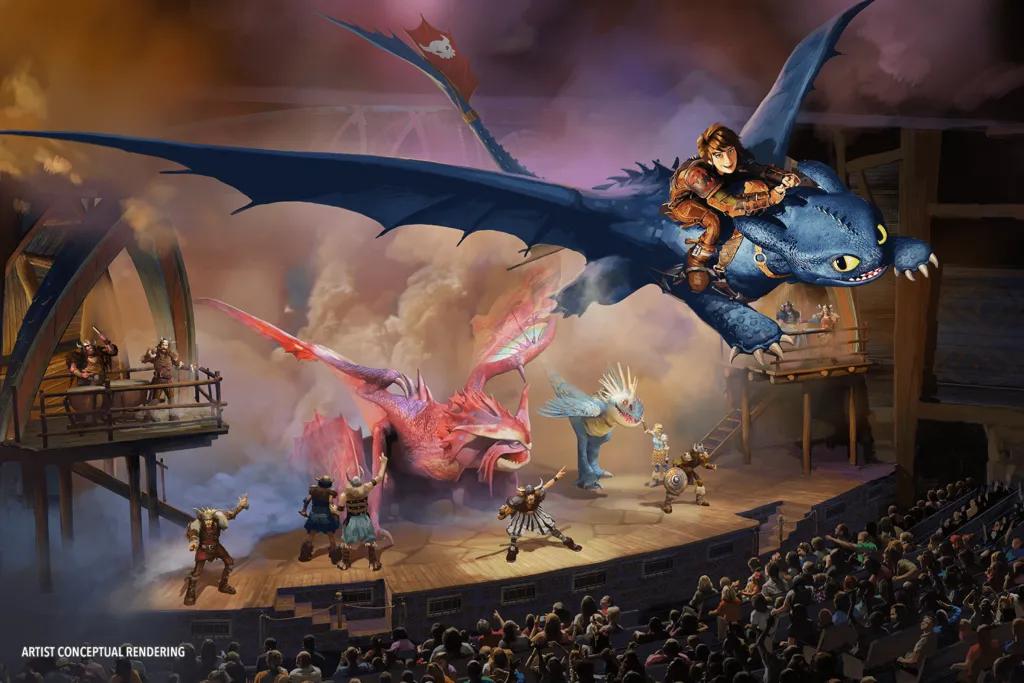 Dragons on the stage next to Vikings looking up at Toothless and Hiccup flying through the sky together above the audience.