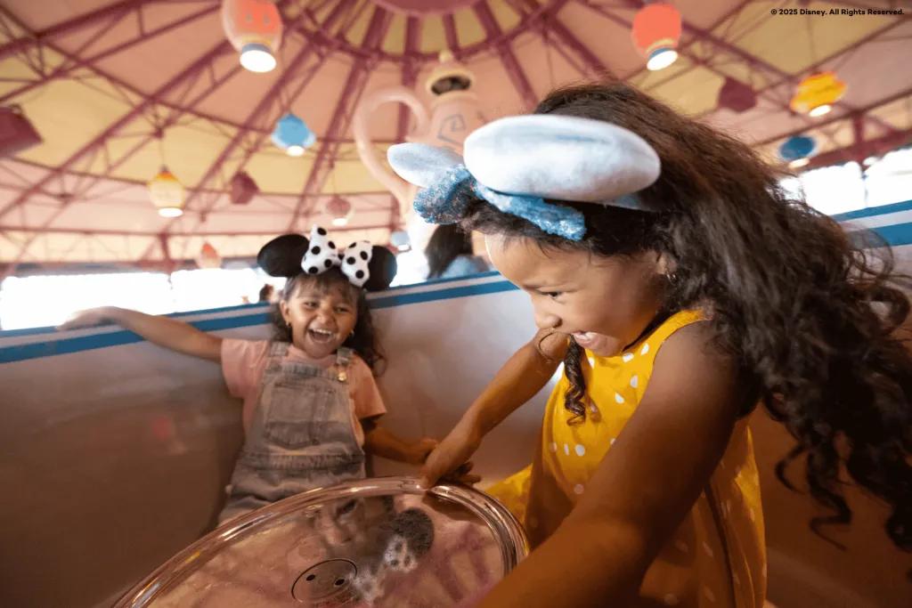 Two young girls on a spinning teacup ride