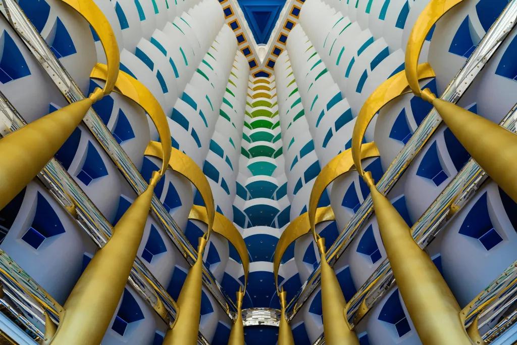 Gold pillars holding up the grand multi-coloured structure which has different colour for each floor. The inside is open in a triangle shape.