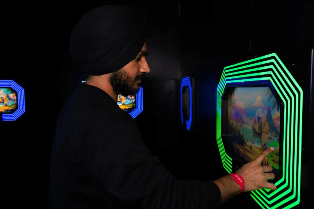 Man tapping a screen in a dark room which has an image with a neon green border.