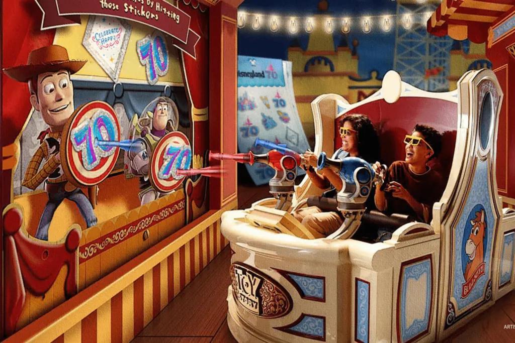 People sat in circular cars with shooters which target the toys on the screens holding up targets. Instead of the usual targets though, instead  it's the 70th anniversary logo.