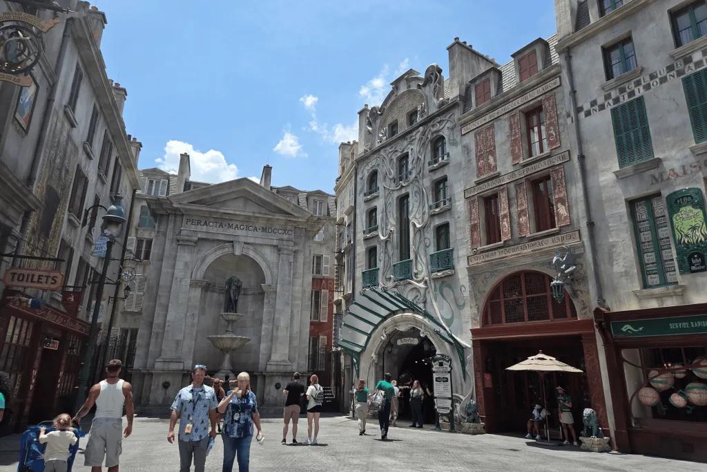 Large tall buildings with Parisian style creating a square where people can shop and cast spells.