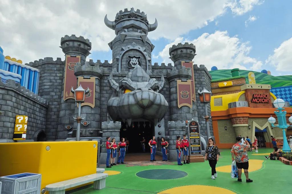 Themed land just like Super Nintendo with red, yellow, green and blue videogame style elements and a grey building in the middle with creature mouth opening as the entrance.