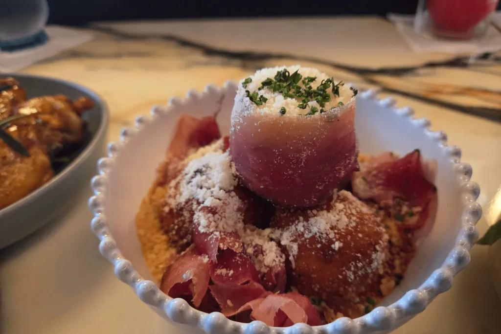 Delicious food presented in a bowl including pastry, cheese and other ingredients.