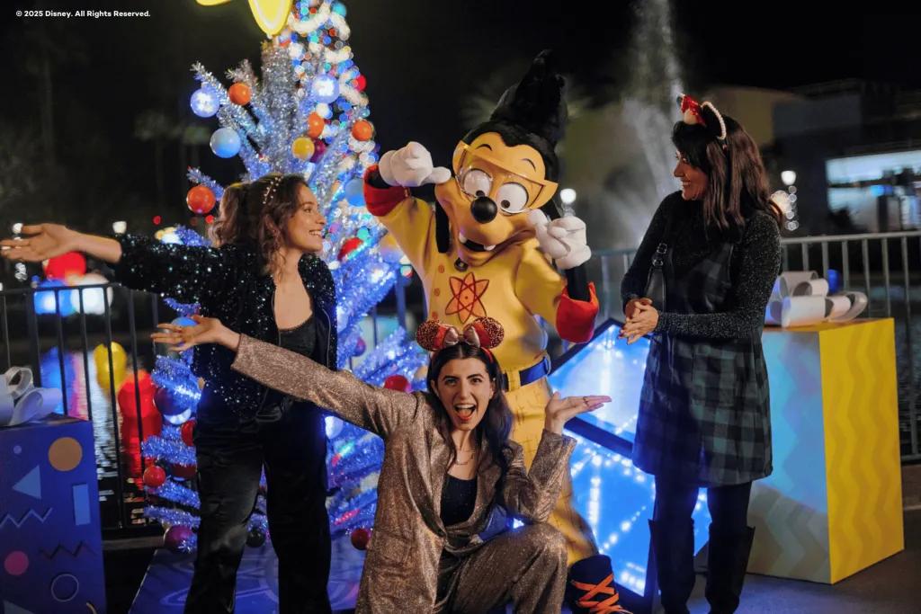 Three women posing for a photo with Max Goof dressed as Powerline from A Goofy Movie