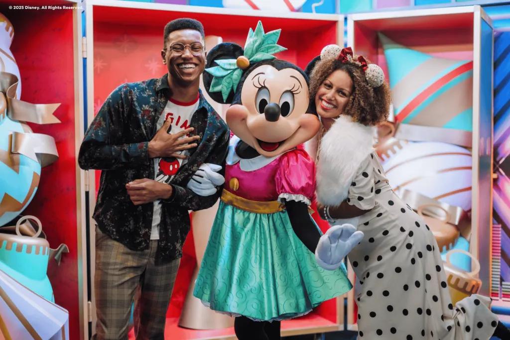 A man and woman posing for a photo with Minnie Mouse