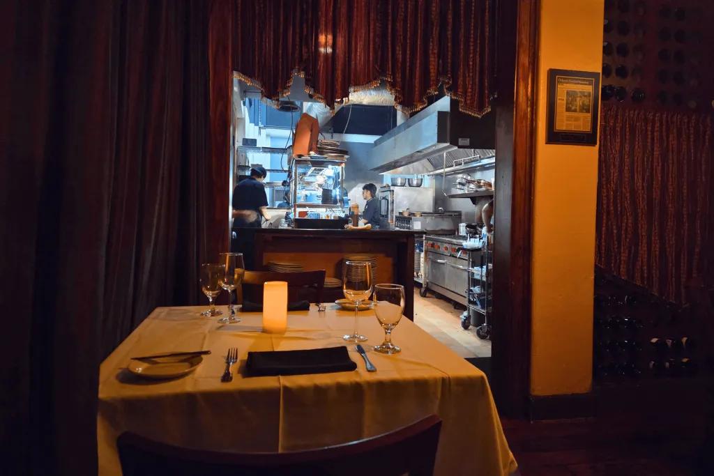 A table set for dinner located next to an open kitchen