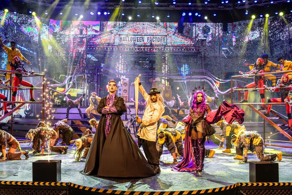 Halloween performers on a stage designed to look like a factory