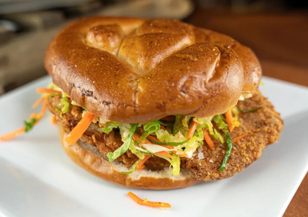 A pork schnitzel sandwich with coleslaw on a plate