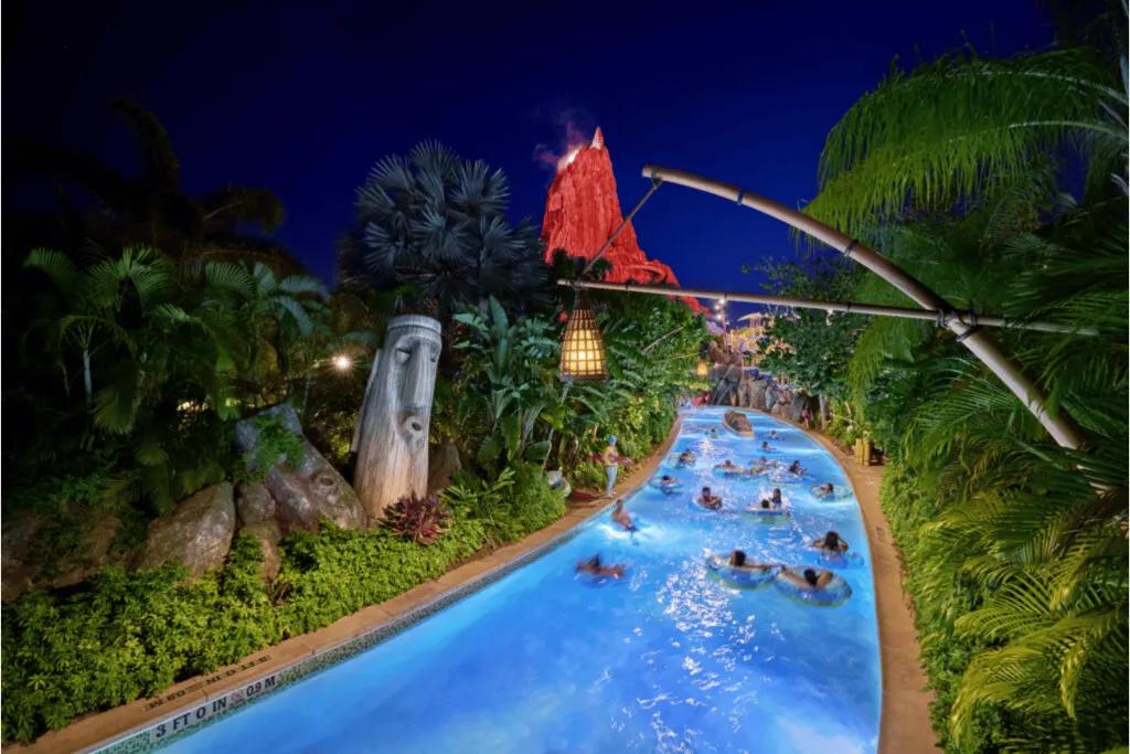 A family of four excitedly riding a circular raft down a rushing river, fully embracing the water on a ride at Universal Islands of Adventure.