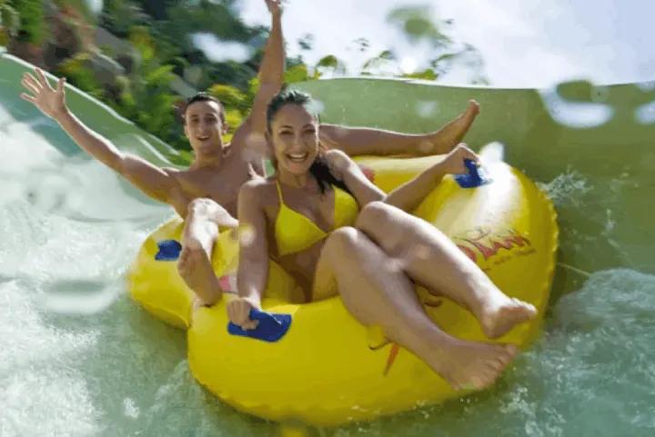 A couple riding a water slide at Siam Park