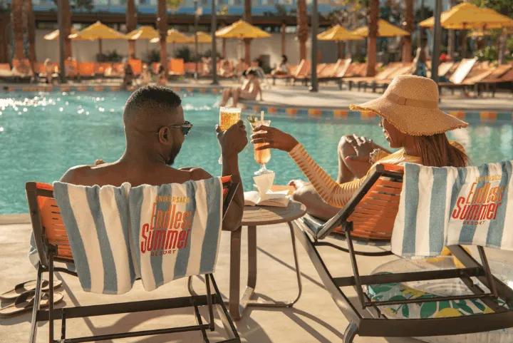 A couple sitting by the pool at Endless Summer - Dockside Inn and Suites