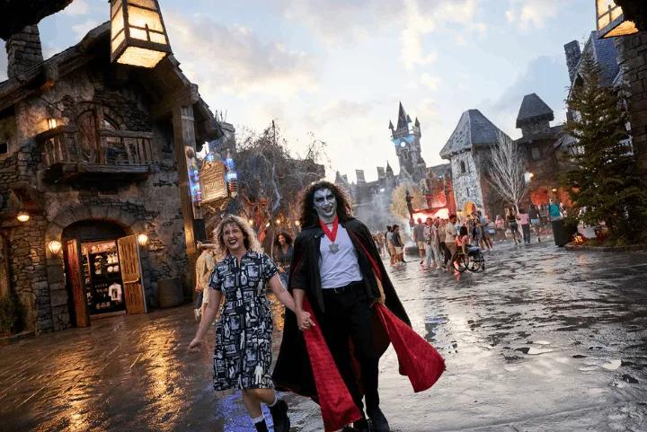 Guests in costume walking through Dark Universe's village at dusk at Epic Universe
