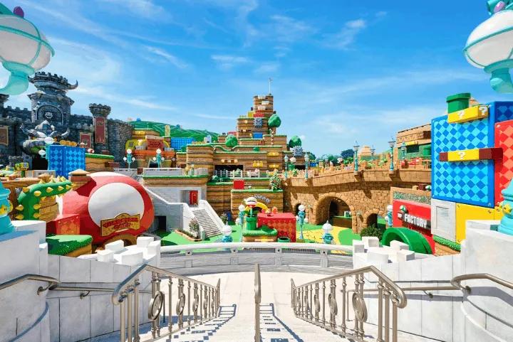 Colorful Super Nintendo World landscape at Epic Universe, featuring Bowser's castle, brick platforms, and themed shops