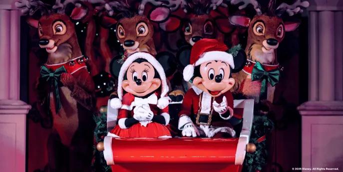Mickey and Minnie in Santa outfits on a sleigh in front of reindeer