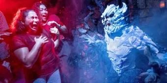 Two women screaming as someone dressed as a snow covered yeti jumps out at them in a haunted house