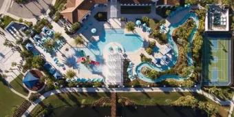 Aerial view of the resort pool complex, lazy river, and sports courts at Windsor at Westside