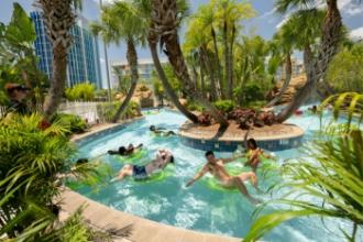 Lazy River in Universal Cabana Bay Beach Resort with several happy-looking guests floating on the water under palm trees