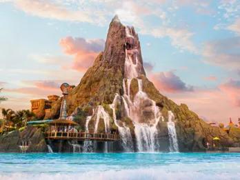 A large volcano spilling water into a water park wave pool