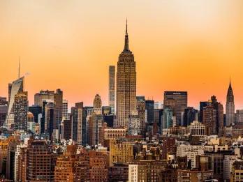 Buildings in New York with the Empire State Building in the centre, during sunset
