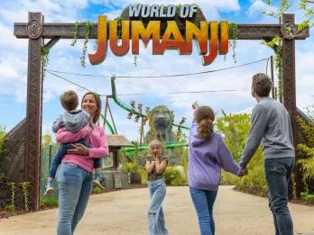 A family standing in front of a sign reading World of Jumanji. One child is holding her face as if in shock
