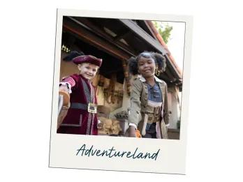 Image of two young kids in pirate costumes with the label "Adventureland" on the polaroid frame. The boy is holding a toy sword up towards the camera in a red coat and pirate hat. The girl is wearing a brown coast with a black eye patch on her forehead. She is also holding a toy sword off camera.