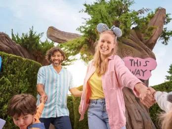 Mutter und Vater werden von ihrem Sohn und ihrer Tochter inmitten eines Heckenlabyrinths in die Kamera gezerrt