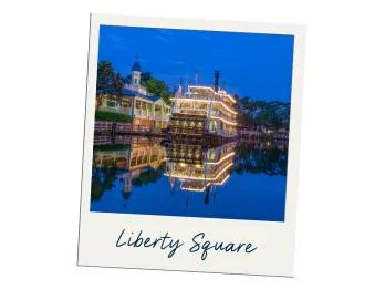There is a large lake with some trees lining it. Docked up there is a large 3 storey steam boat called the "Liberty Belle" lined with yellow lights.