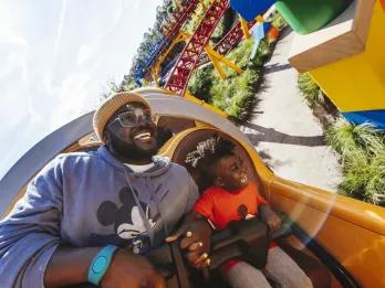 A father and son riding Slinky Dog Dash at Disney World