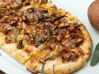 Eine lange Pizza, belegt mit herbstlichen Zutaten