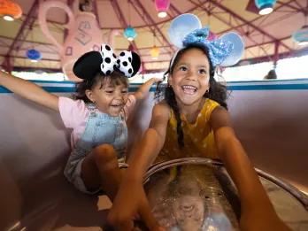 Two young girls in a spinning tea cup ride